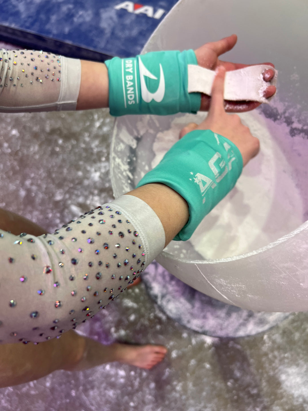 Gymnast chalking up at competition wearing DRYbands, best wristbands for gymnastics